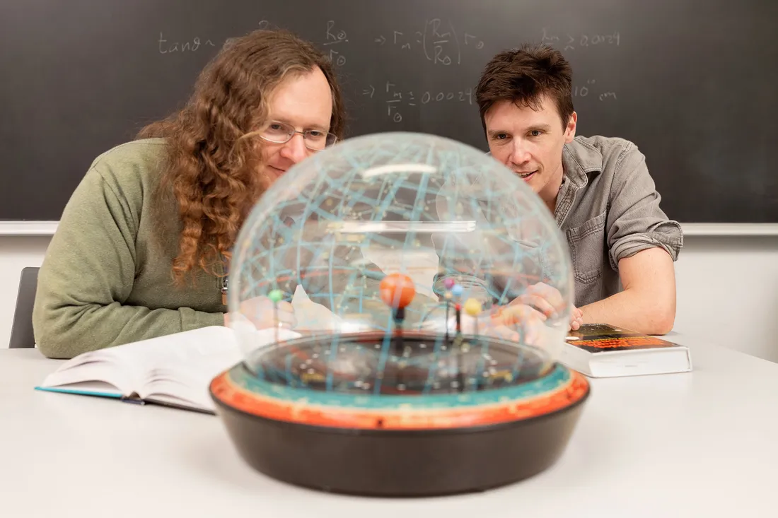 Two people looking at a globe.