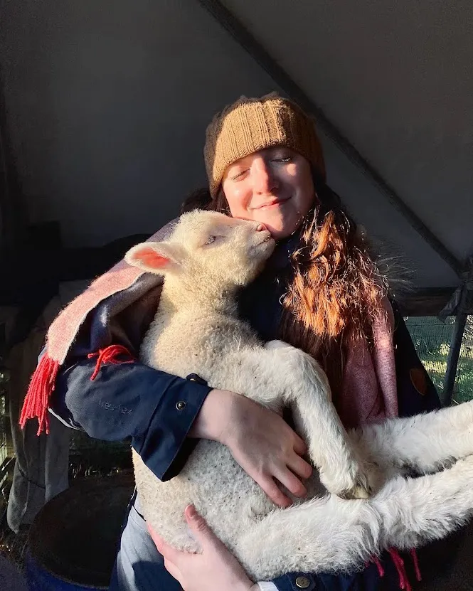 Isabelle Collins holding a lamb.