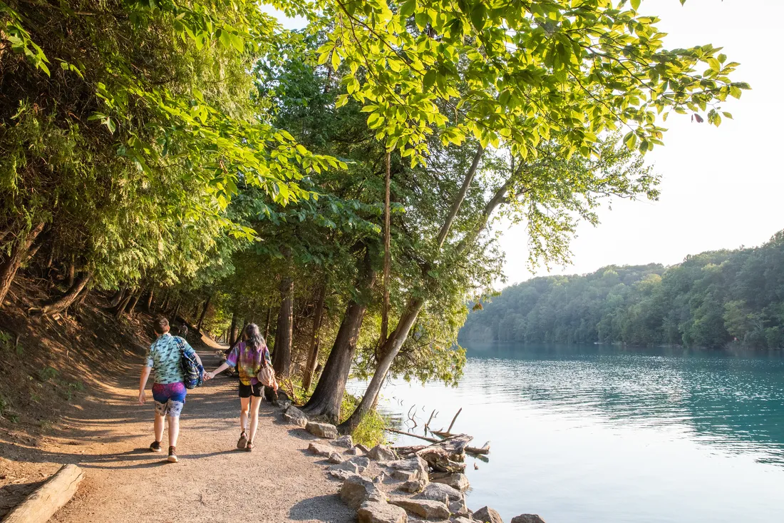 People holding hands on the trail at Green Lakes State Park.