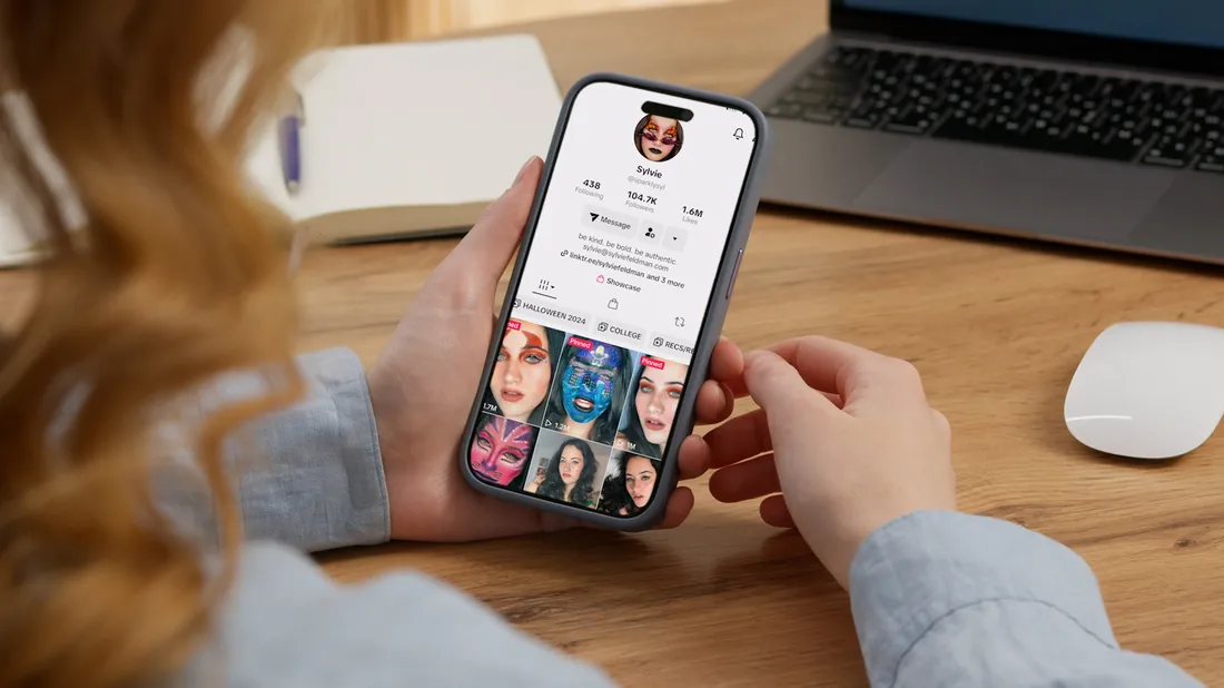 Someone holding a phone that is displaying a tiktok profile.