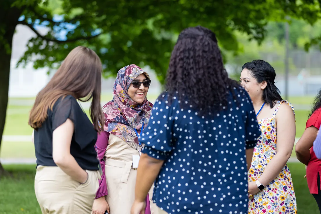 Students talking with their mentors outside.