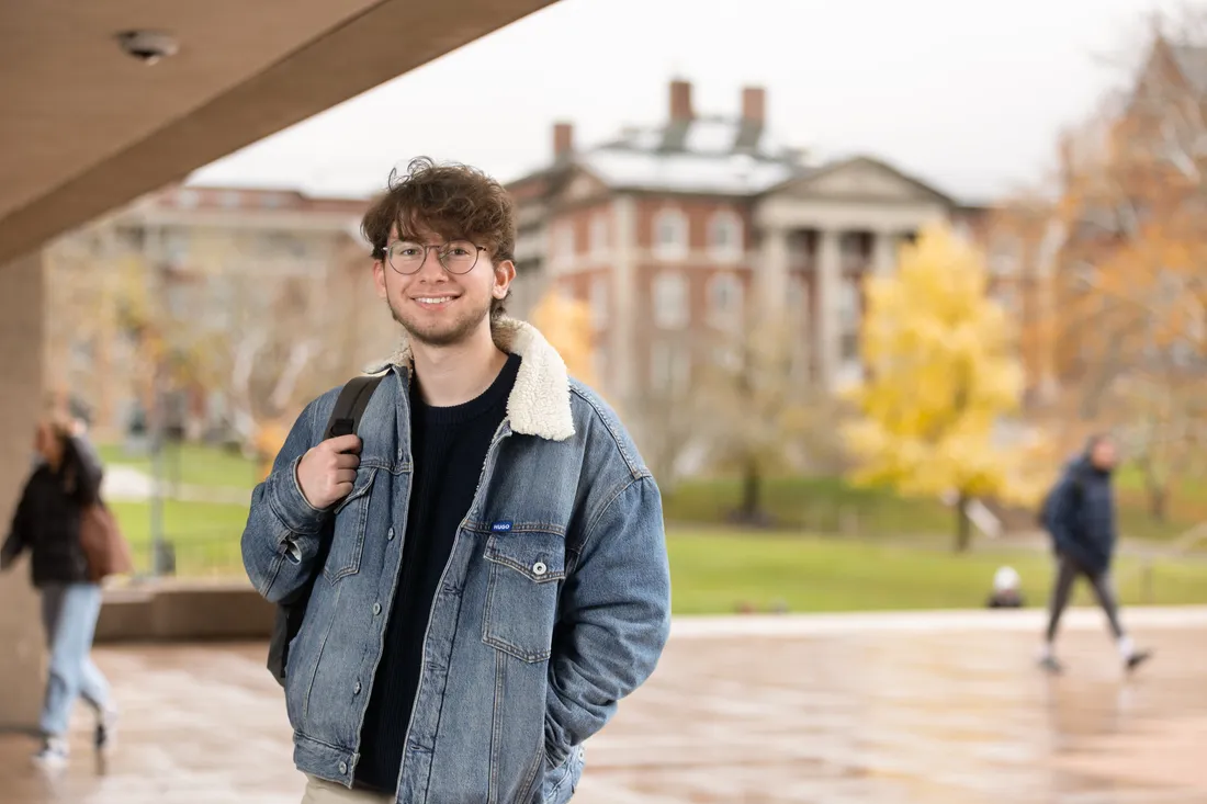 Person standing and smiling outdoors.