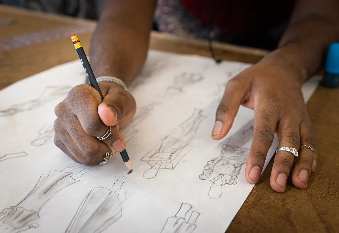Hands drawing fashion models.