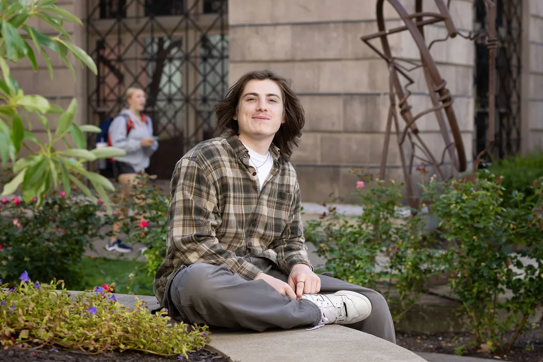 Kyle Henry ’26 sitting on bench outside.