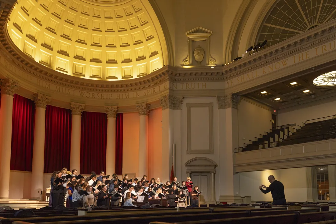 Person conducting a choir inside of the Hendricks Chapel.