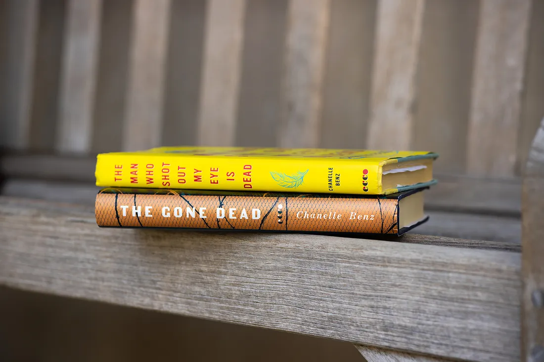 Stack of two books sitting on bench.