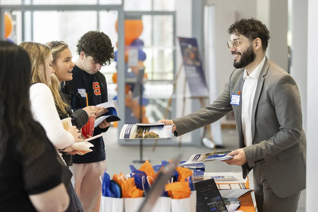 People passing out pamphlets to students at Syracuse University's Career Conference.