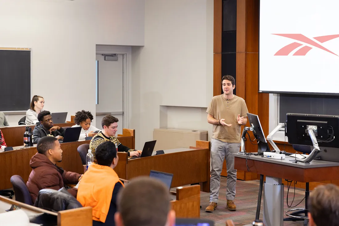 A student stands in front of a classroom and gives a presentation.