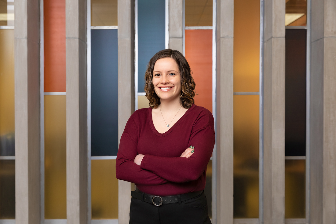 Mackenzie Mangos standing with her arms crossed, smiling.