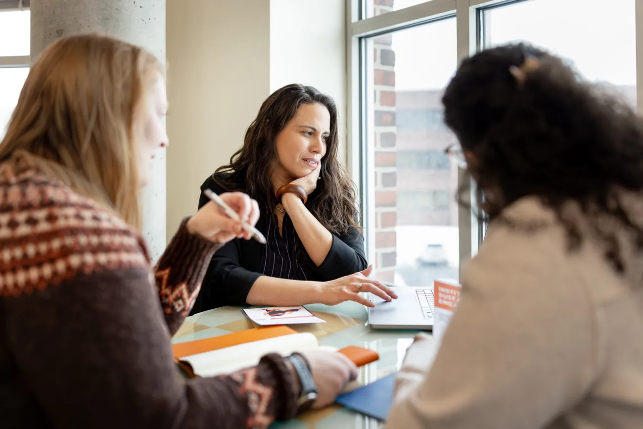 Melissa Young, director of Syracuse University's Institute for Sustainability Engagement (ISE), sitting at a table with other ISE members.