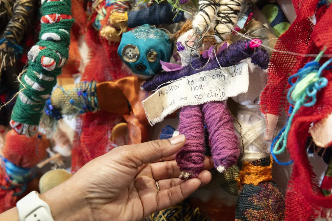 Rochele Royster holding a doll with words of grief written on it.