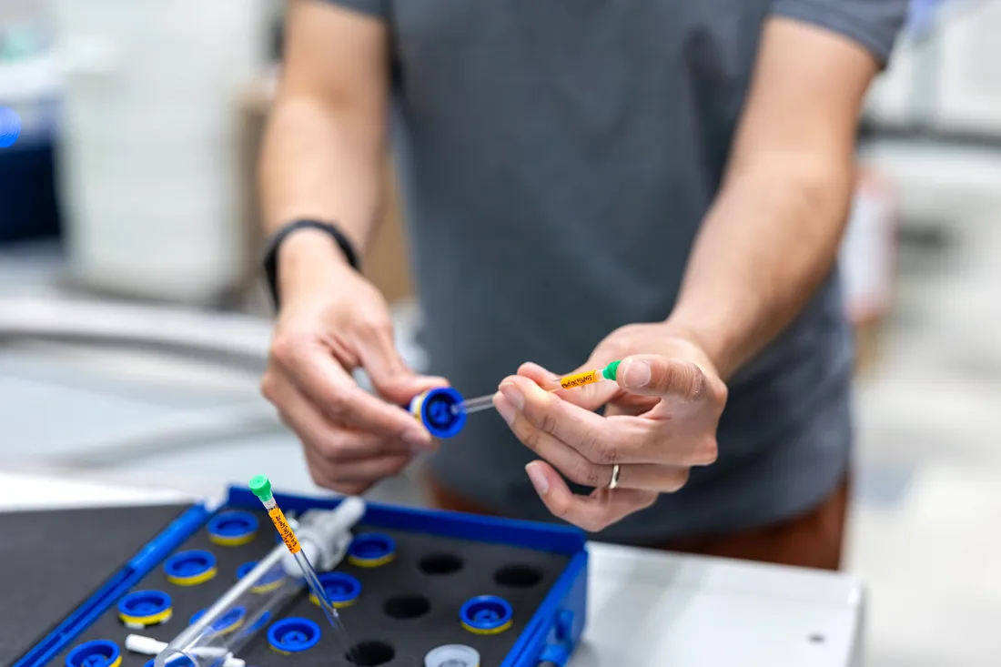 Professor Carlos Castañeda using laboratory syringes for his research.