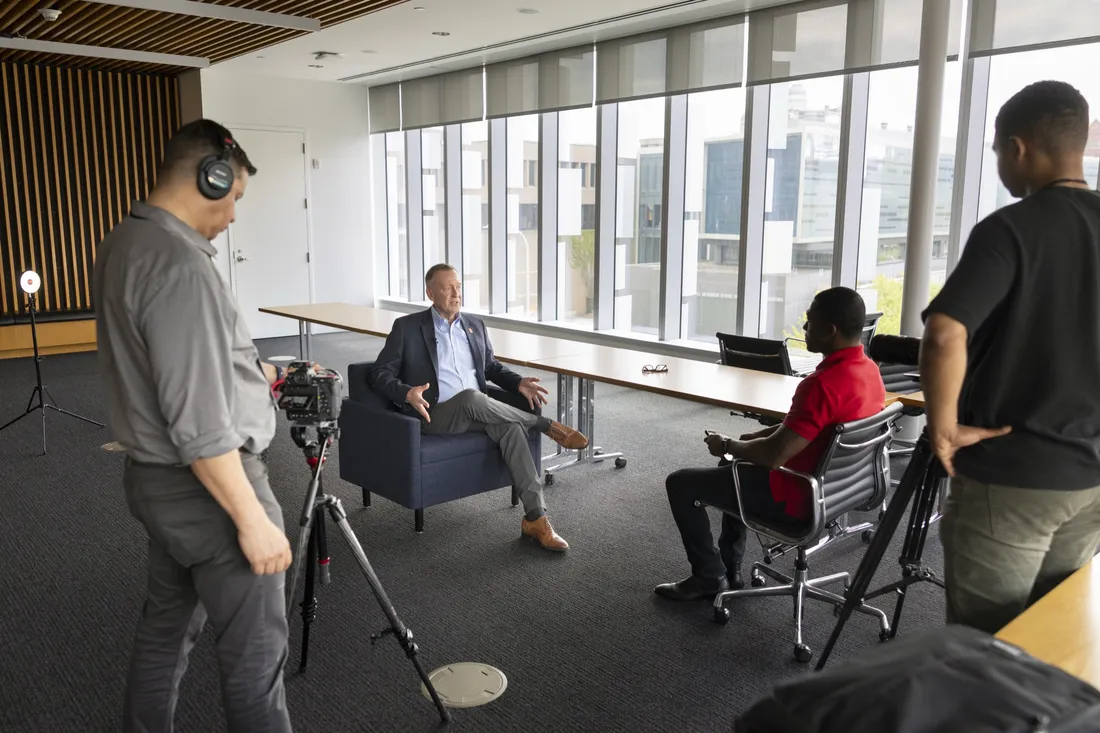 Chancellor Mike Haynie sitting with students for an interview.