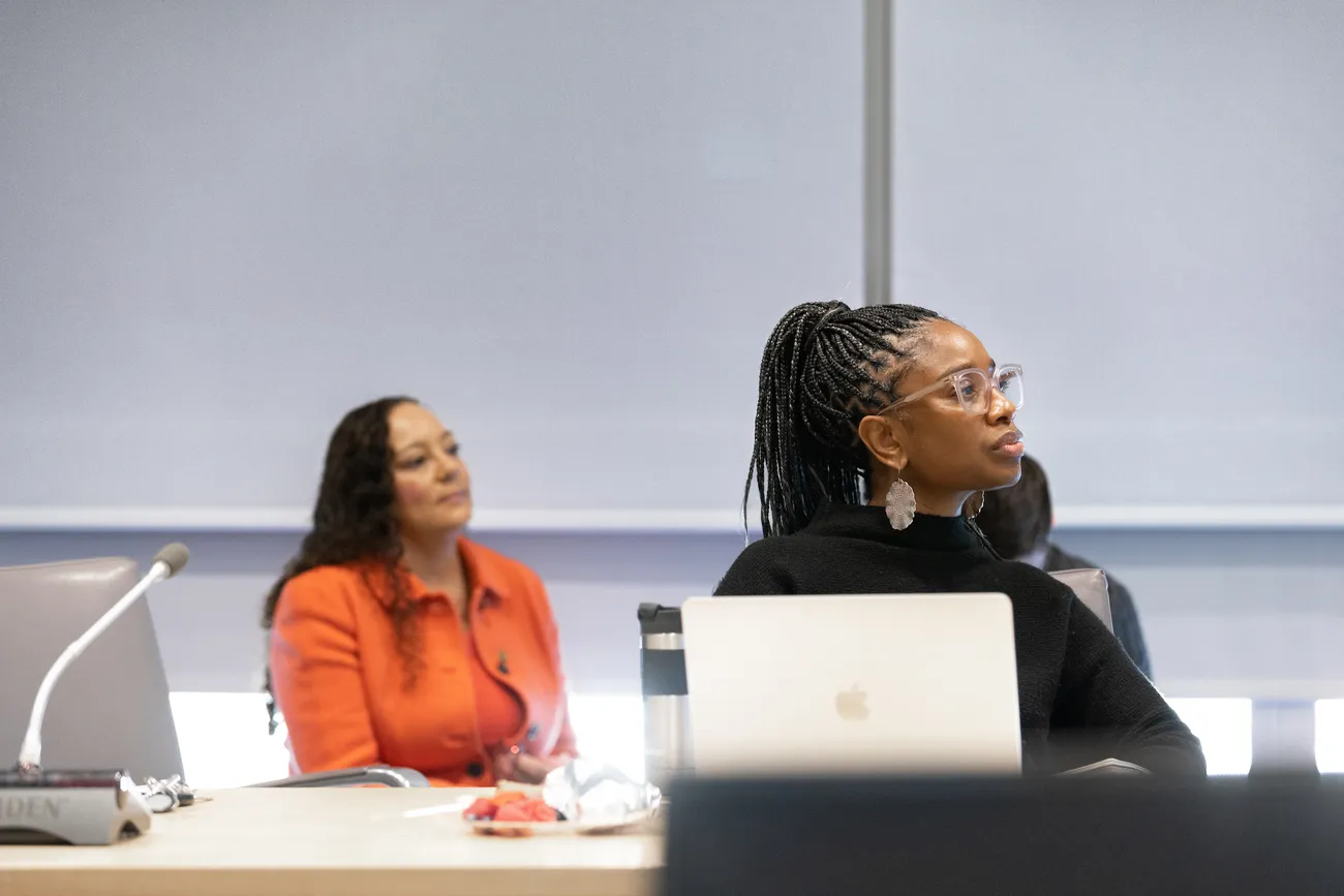 Students sitting at a desk and listening to a lecture.