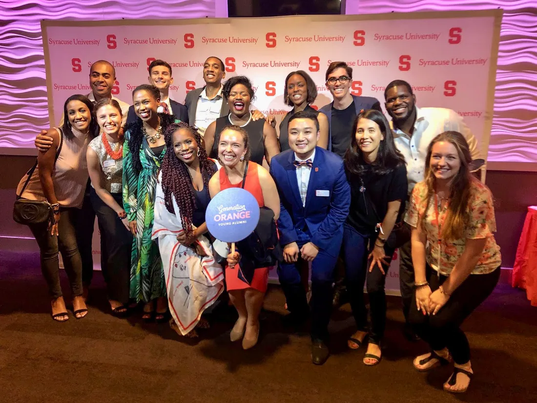 Group of people standing and smiling.