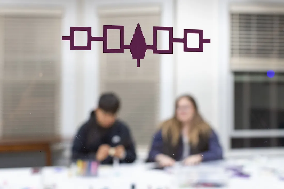 The flag of the Iroquois Confederacy painted on glass inside a building.