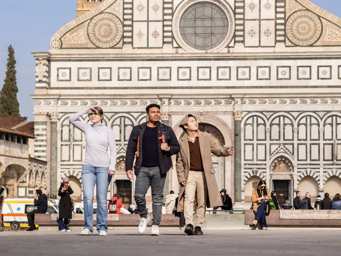 Three students walk through a plaza in Florence.
