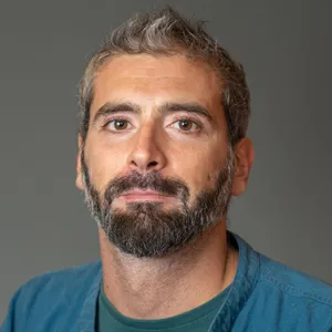 Donato Rossi smiling in a teal shirt.