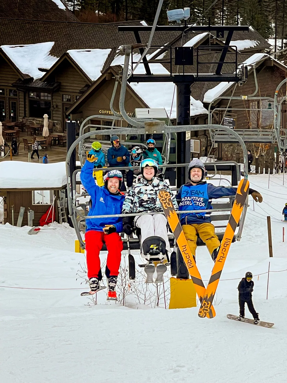 Katie Verderber L'16 sitting on a ski lift with two other individuals.