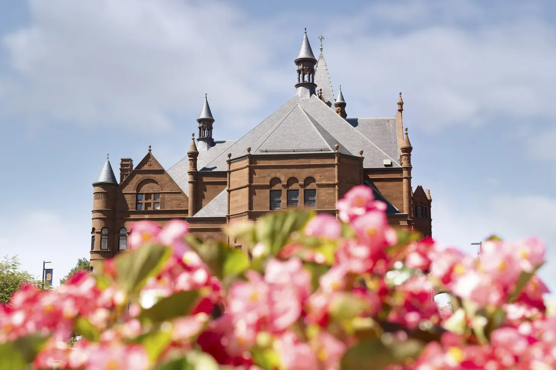 Crouse College with pink flowers in the foreground.