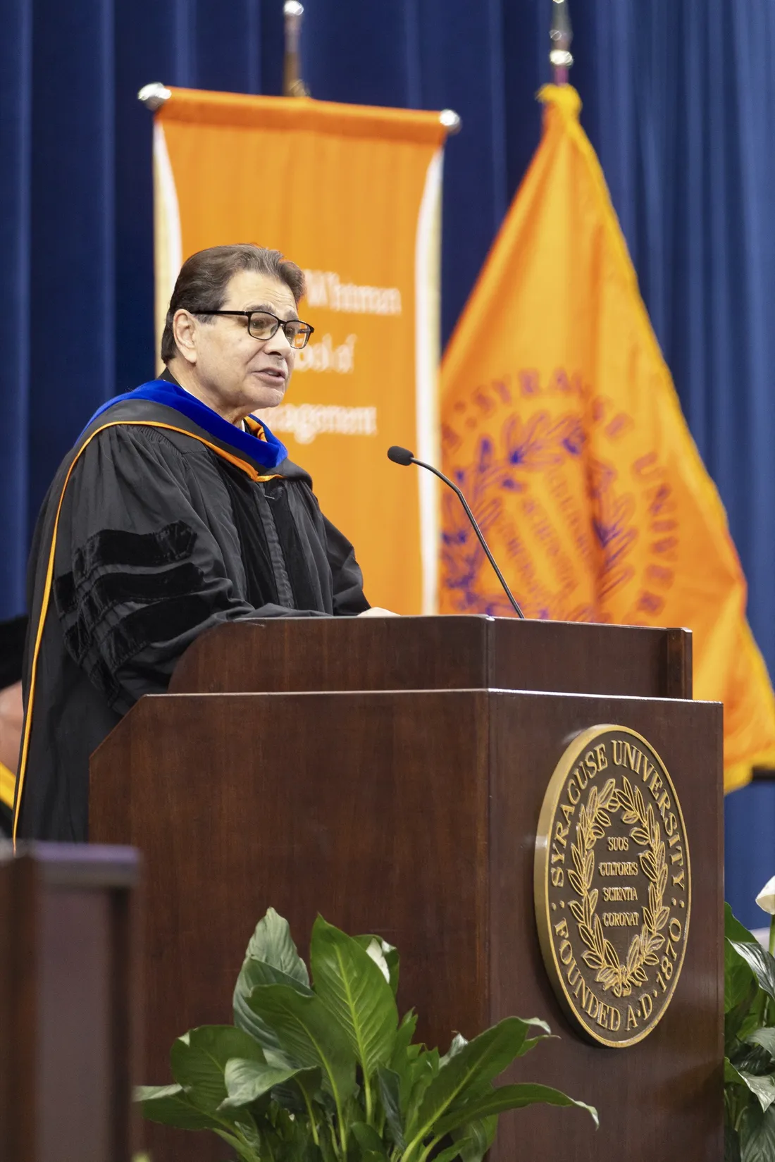 Dan D'Aniello standing at a podium and speaking at a Convocation ceremony.