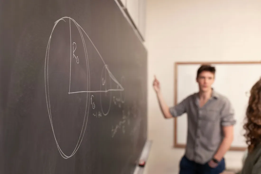 A person drawing on a chalkboard.