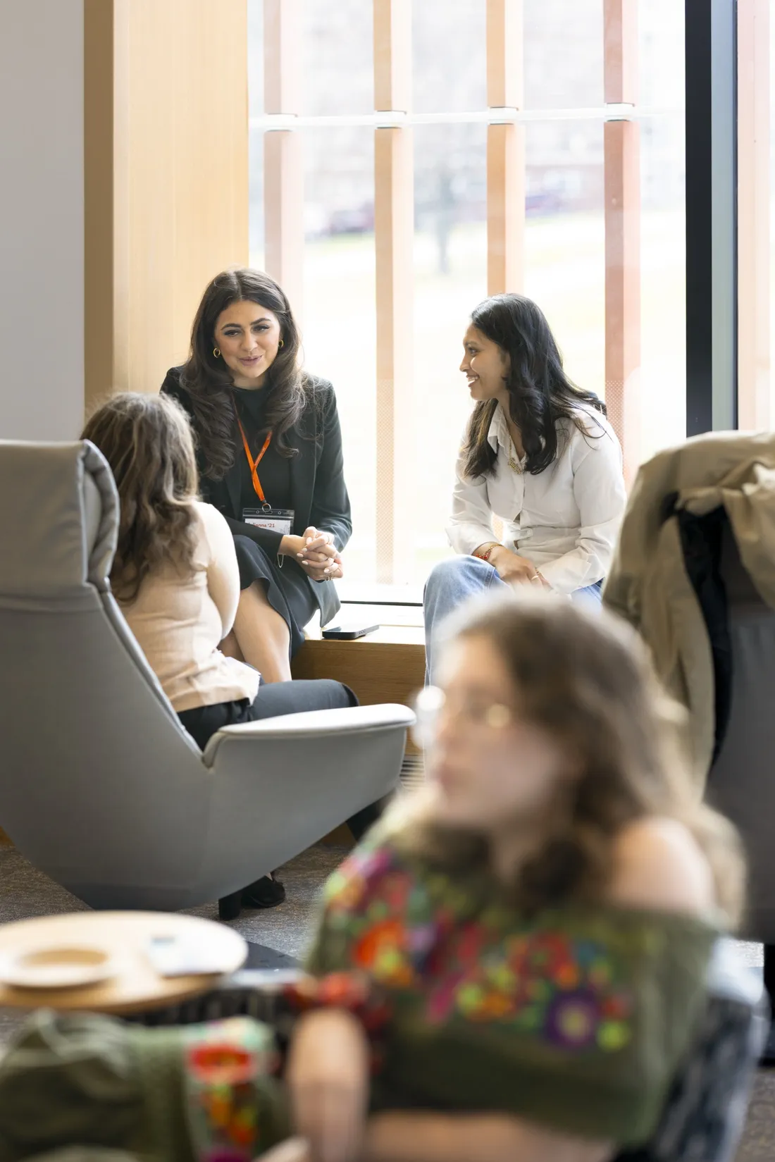 Alumni Julianna D'Urzo and Jalyss Lyann speaking with a student at Syracuse University's career conference.