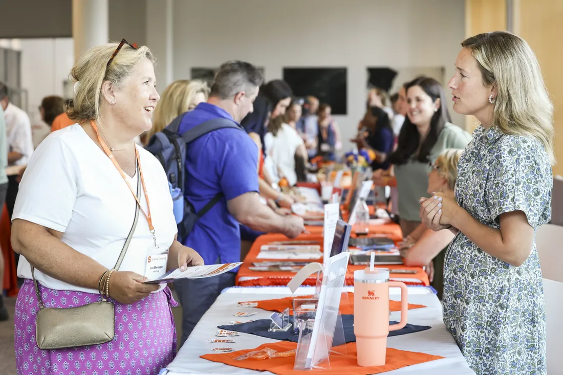 Parents speaking to faculty at the New Student Orientation resource fair.
