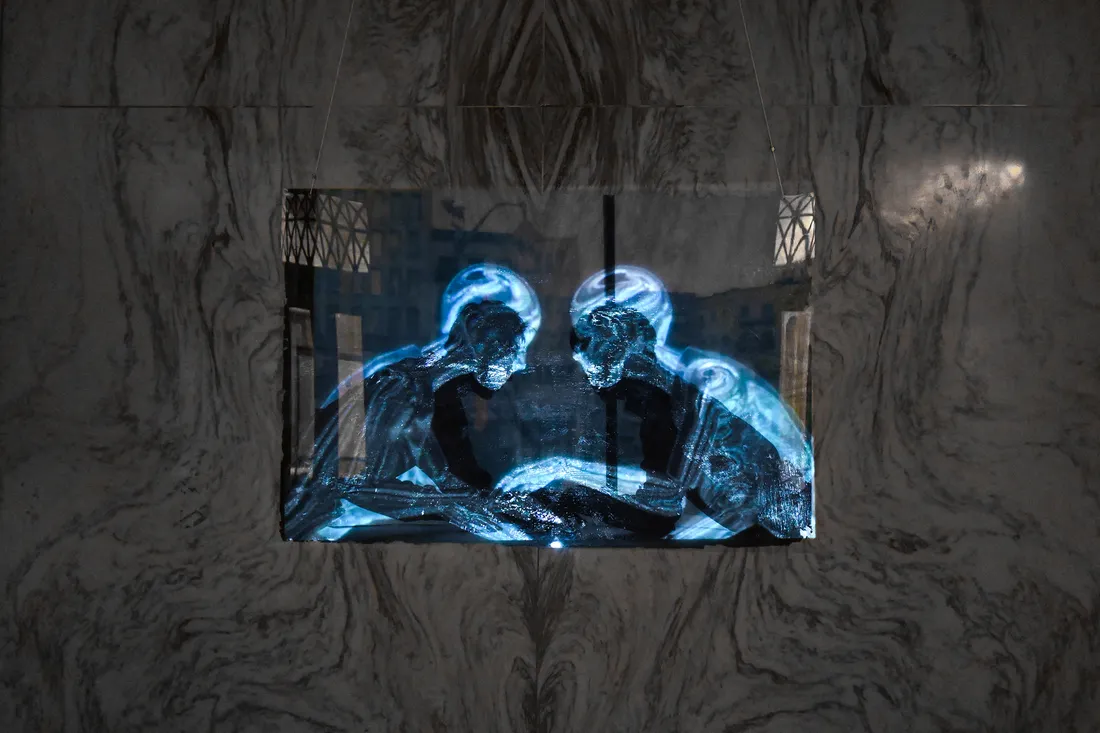 Projection of transparent figures onto marble wall.