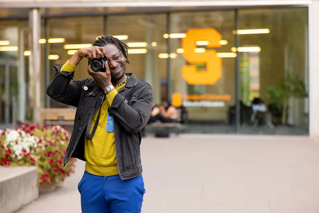 A person taking a photo outside on Syracuse University's Campus.