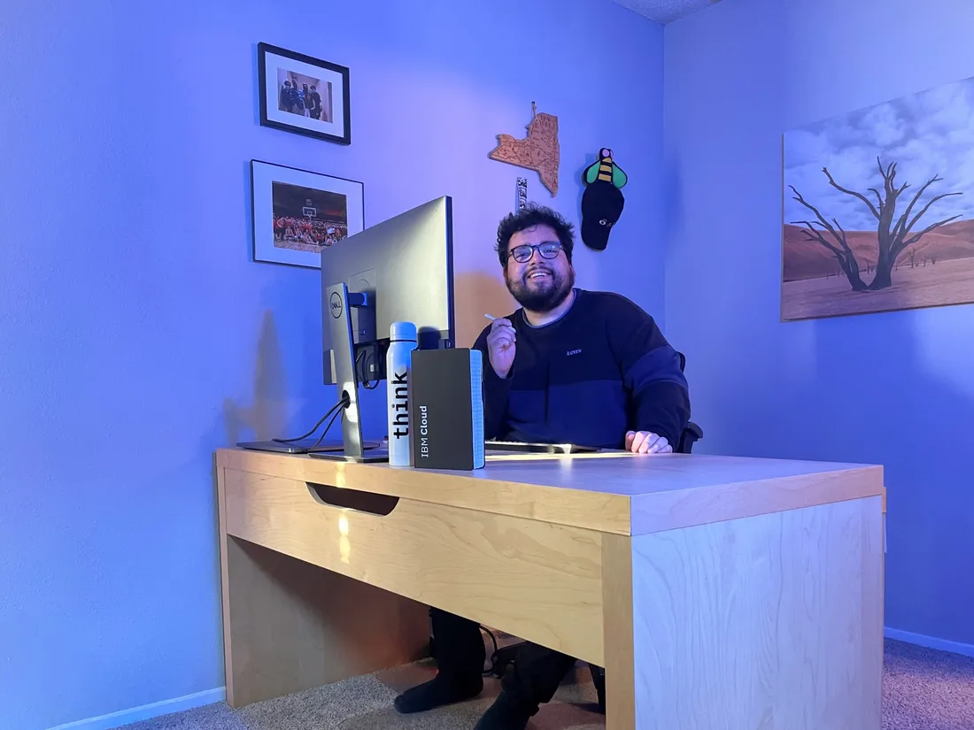 Kevin Camelo Bonilla sitting at a desk, smiling in front of a computer monitor.