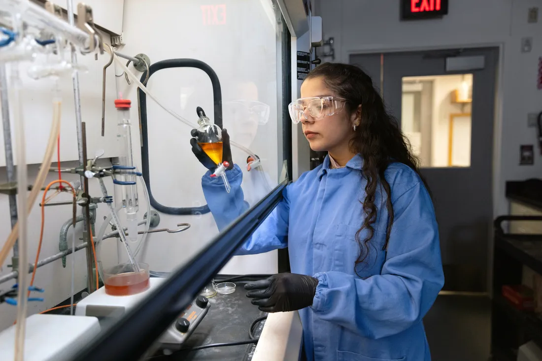 Person using test tubes and lab equipment.