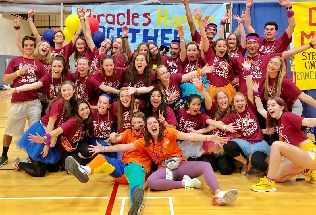 Group of people posing for picture in gym.