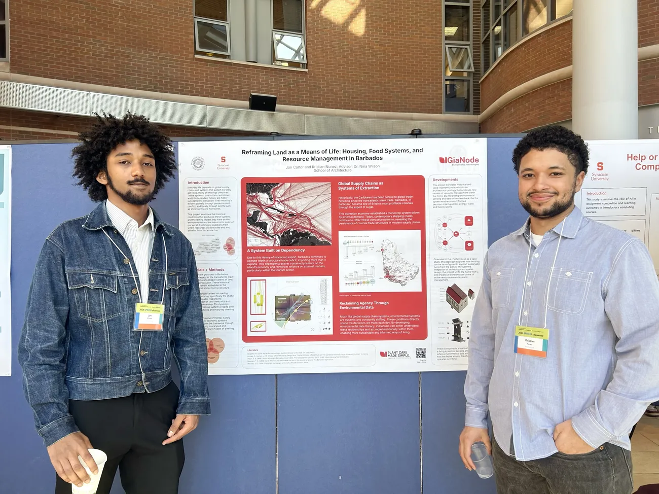 Alumni Jon Carter and Kristian Nunez standing together in front of their poster board presentation.