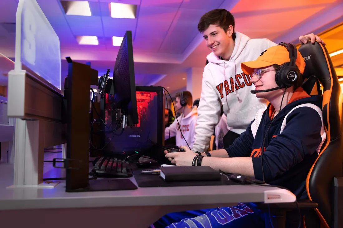 Two Esports players look at a computer.