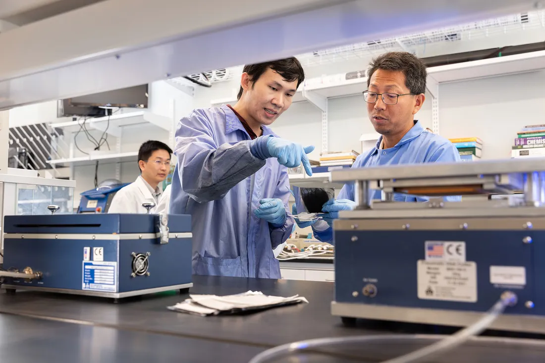 Professor Quinn Qiao is working in the lab with a colleague.