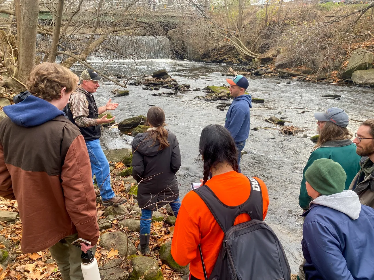 Group of people standing in the woods at the Oswego County Little Salmon River dam.