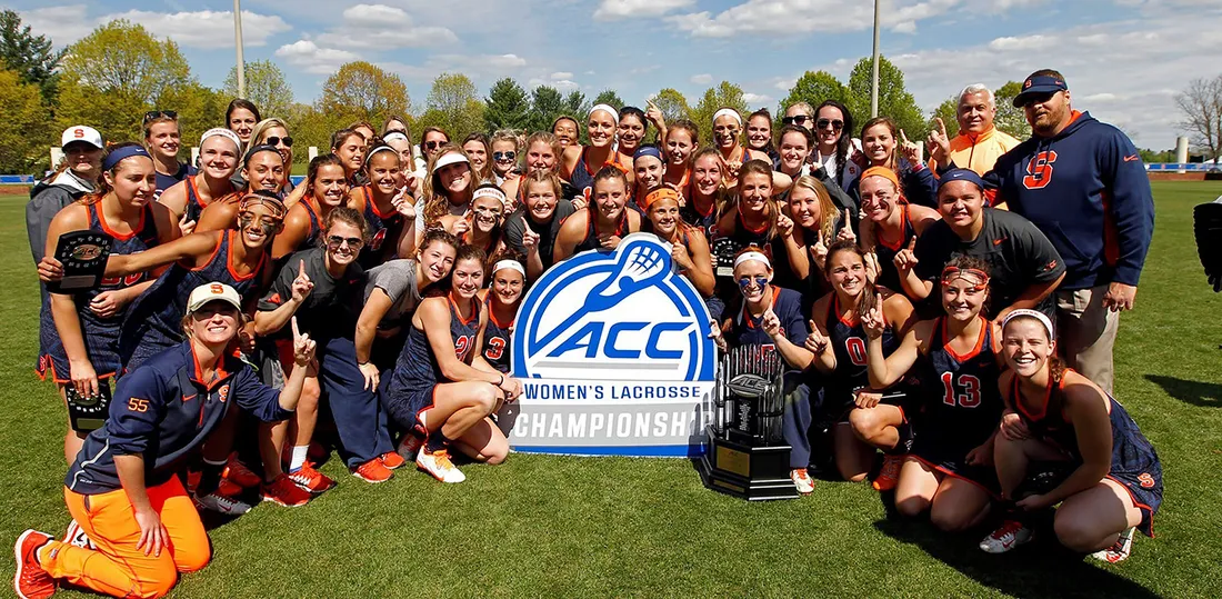 Women's lacross team poses with ACC championship sign.