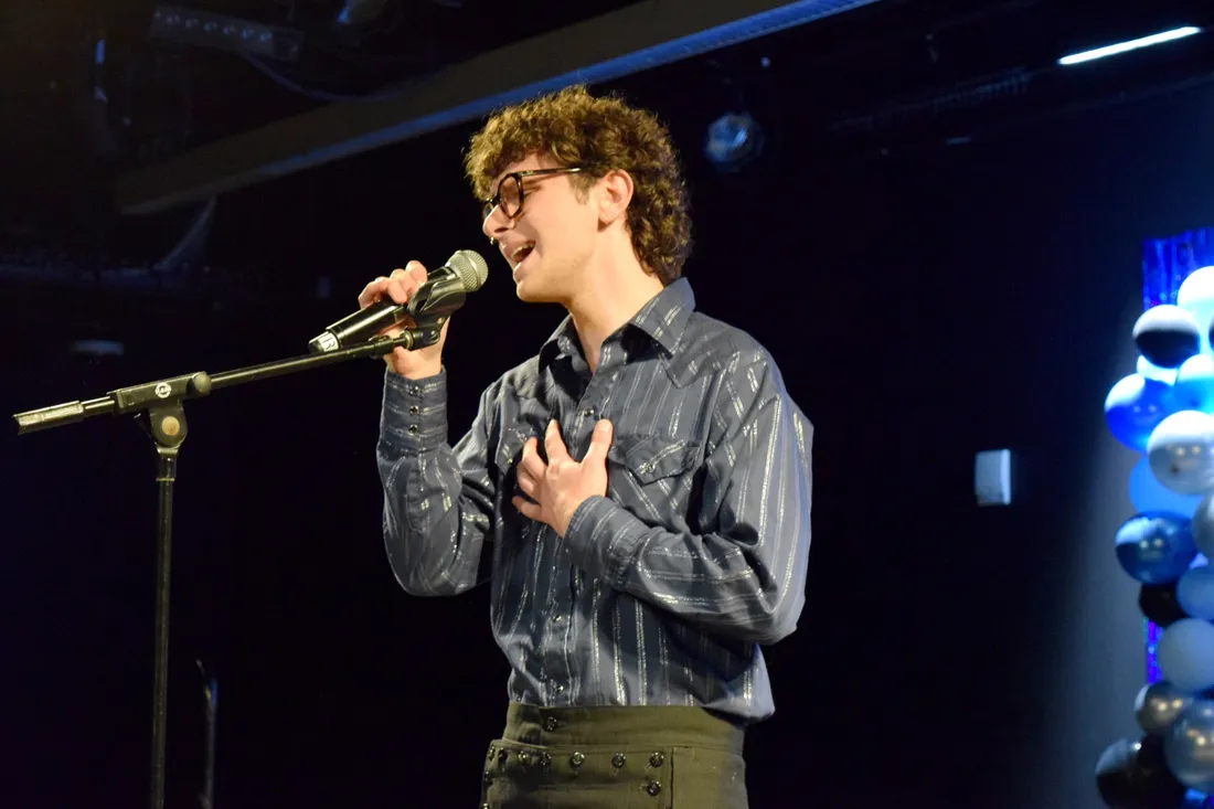 Person singing in a microphone.