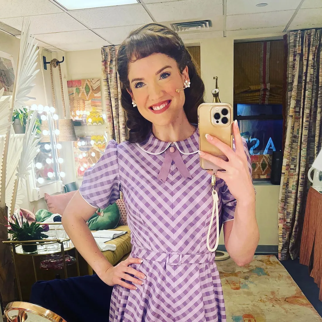 Actress taking a picture in the mirror.