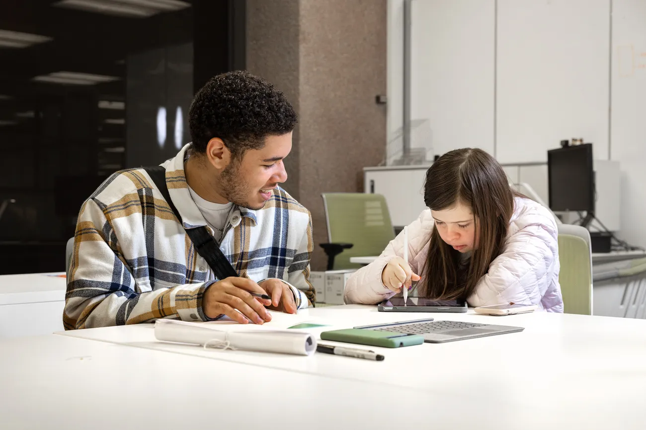 Two people working together at a table.