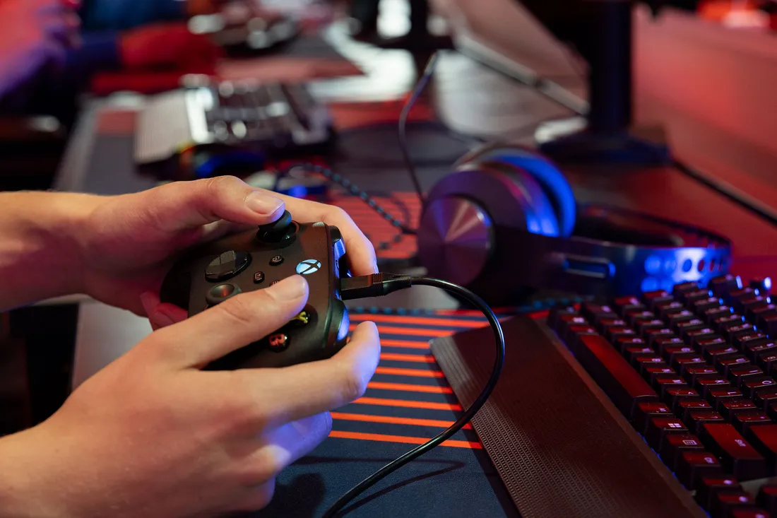 Close up of hands playing video games with a controller.