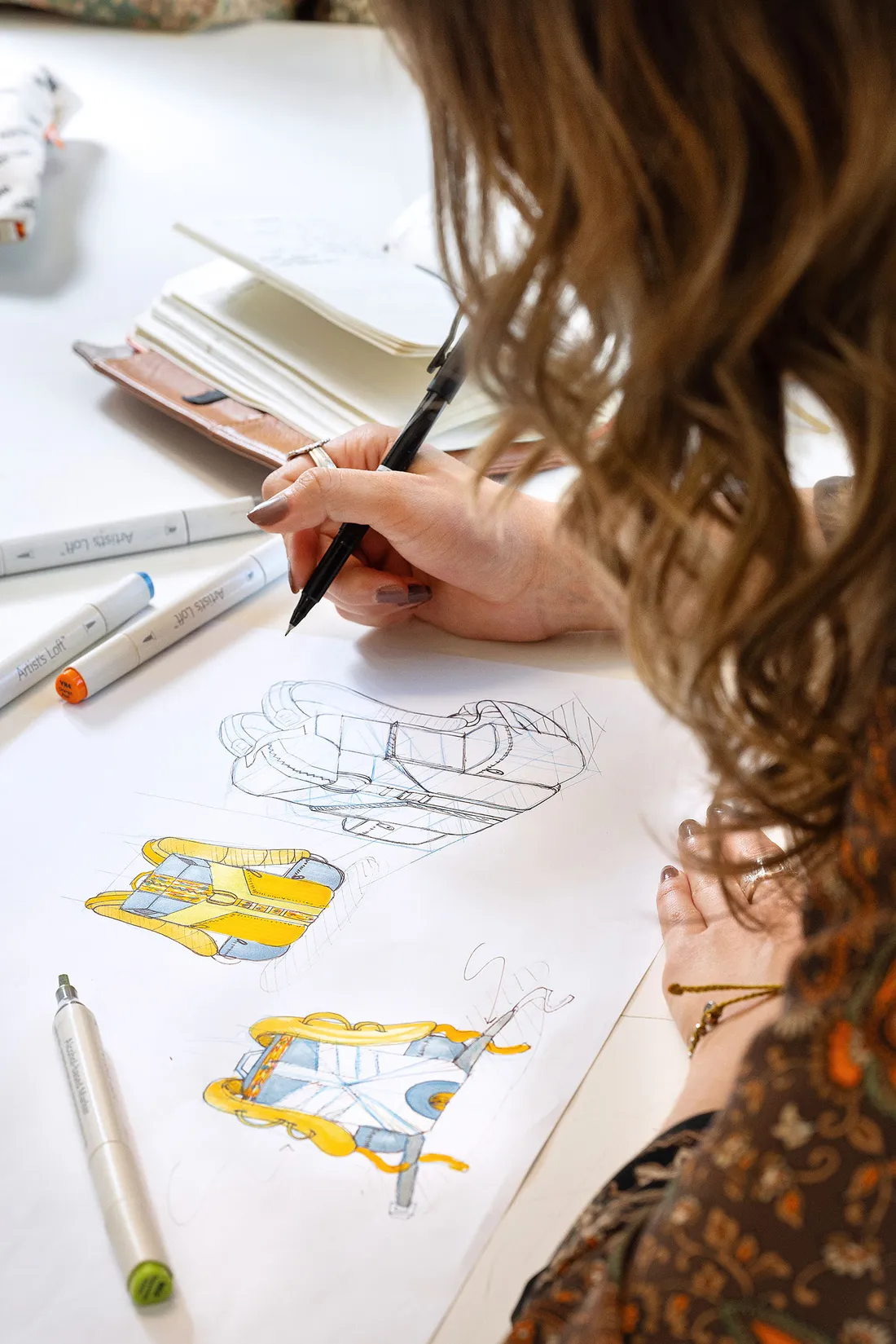 Student drawing sketches of a backpack.