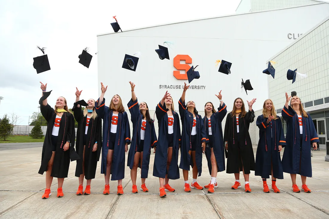 Women athletes throw caps at graduation.