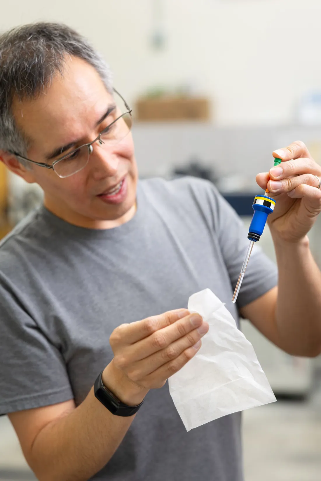 Professor Carlos Castañeda using laboratory syringes for his research.