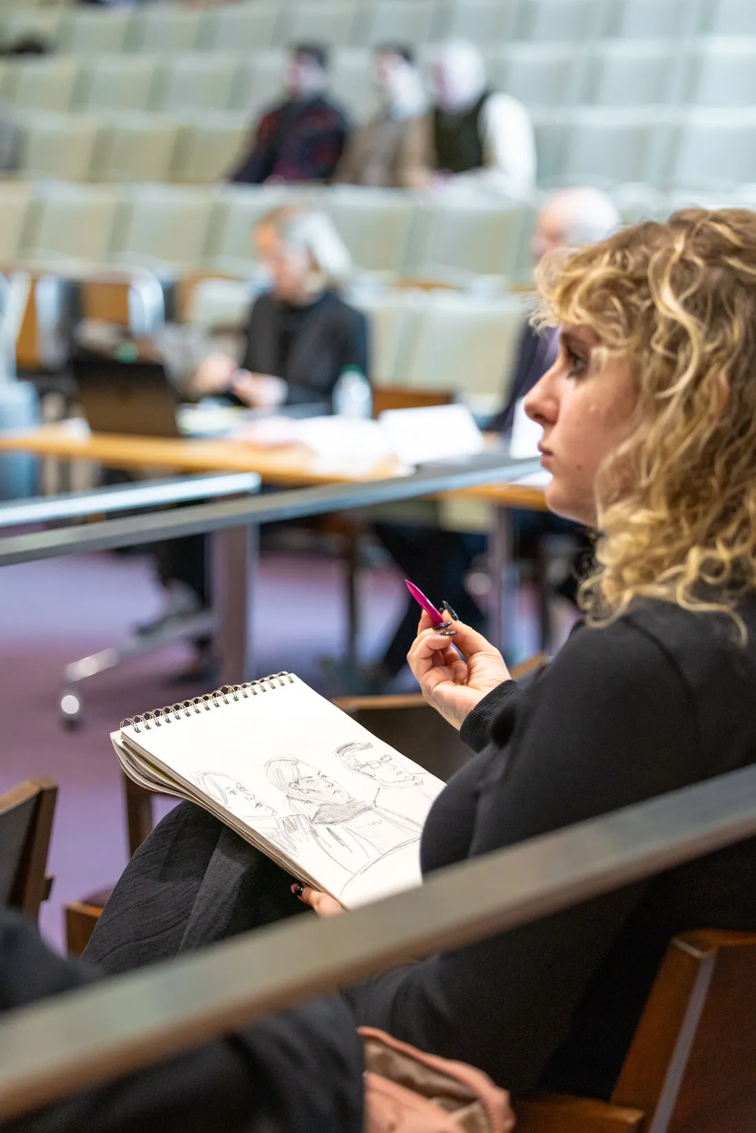 Student making a courtroom sketch in Syracuse University College of Law's Dineen Hall.