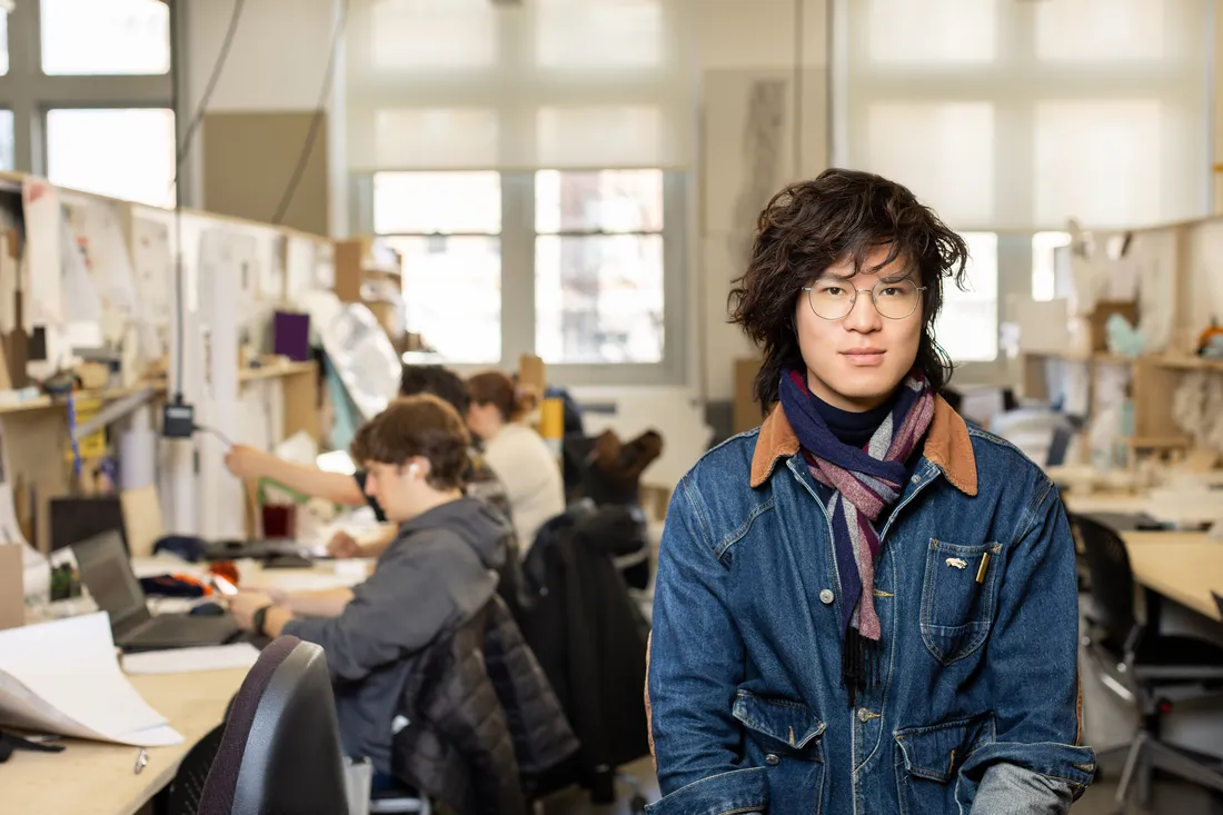 Portrait of a Qianzhen Li posed with the architecture studio in the background.