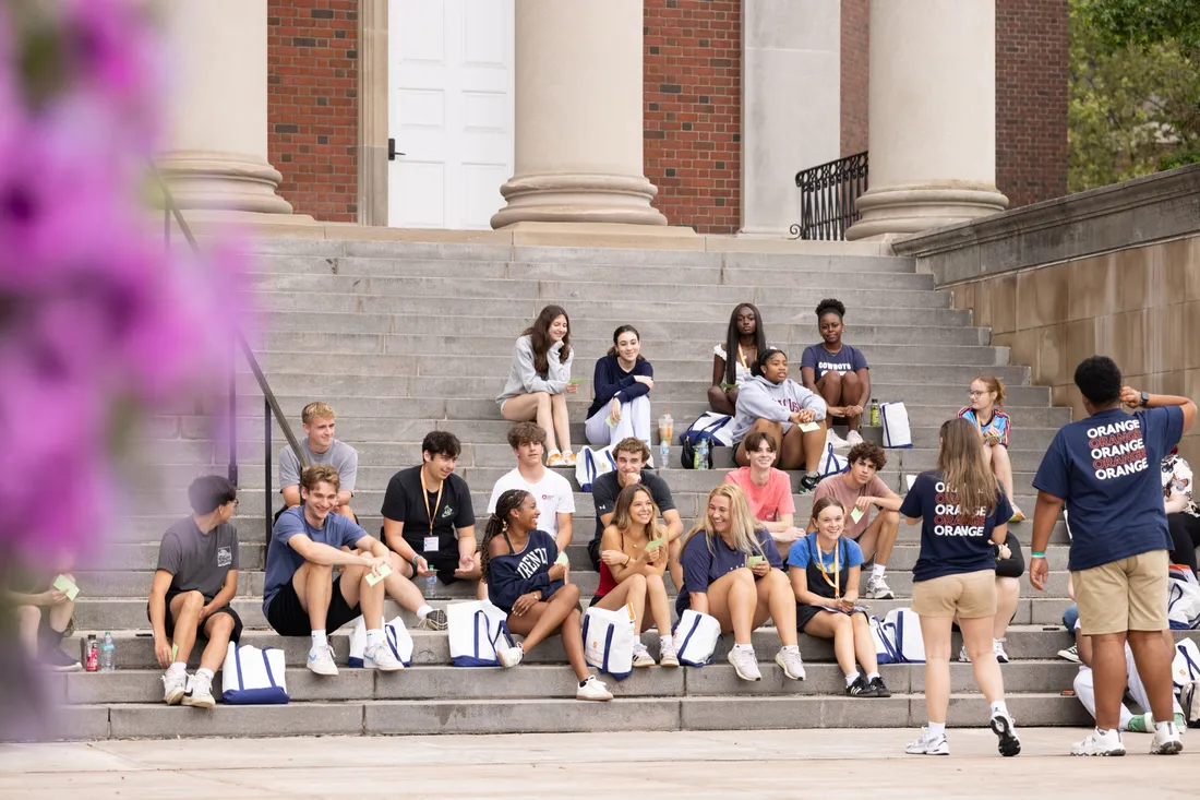 Students sitting on the steps of Hendricks Chapel during orientation week.