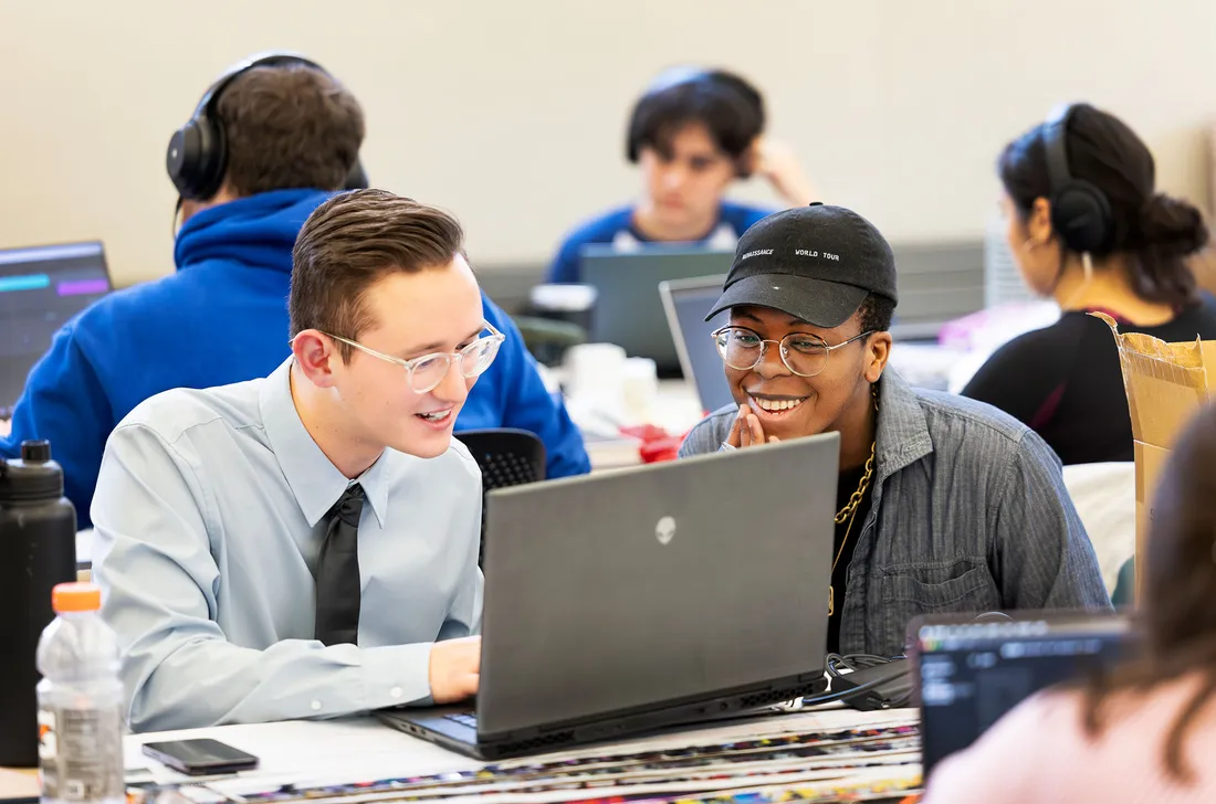 Two people looking at laptop smiling