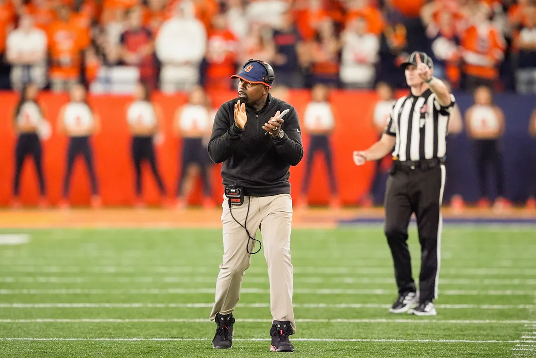 Fran Brown clapping his hands together on the football field.
